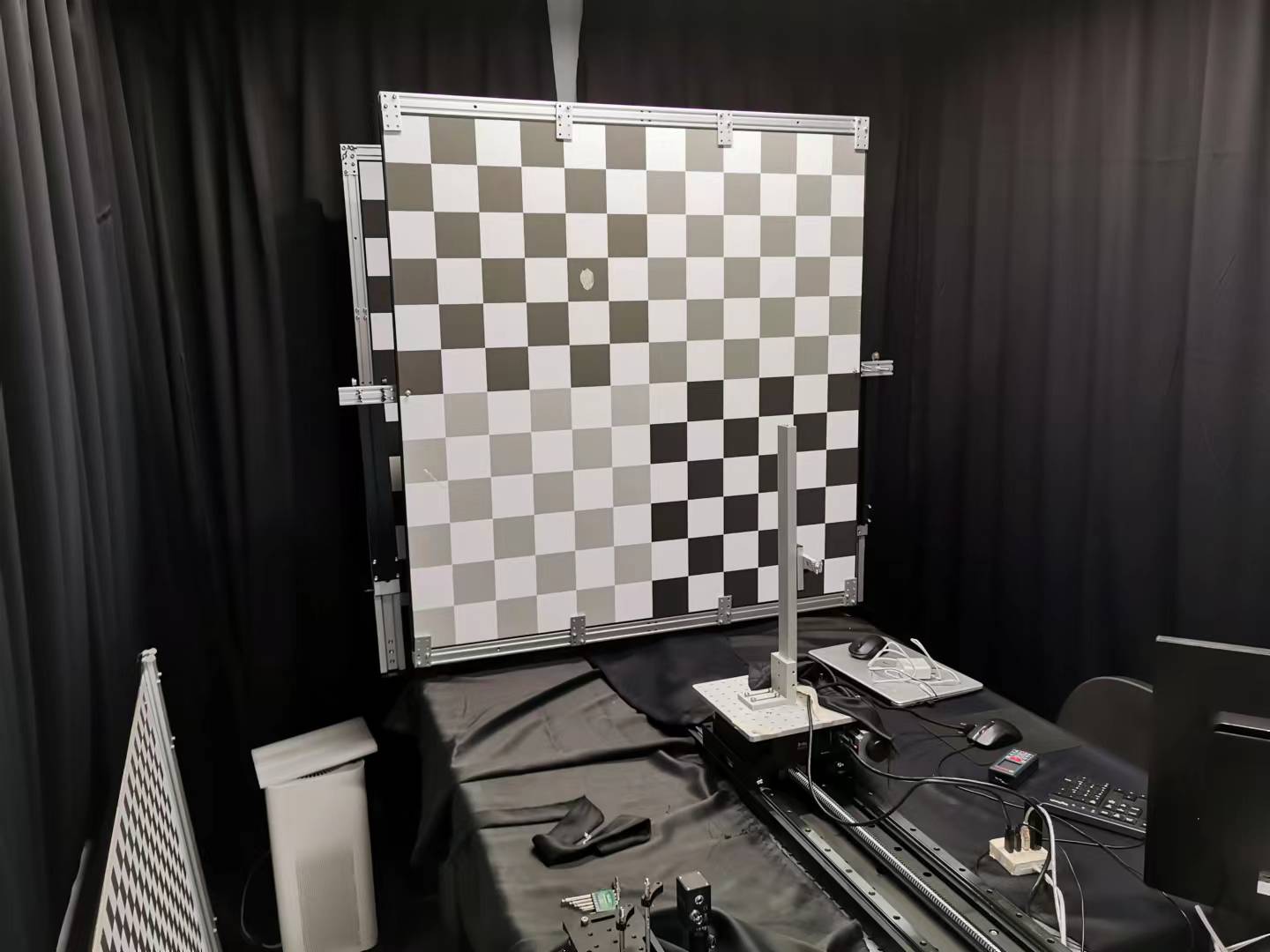 Professional ToF LiDAR sensor calibration lab setup with chessboard calibration target and testing equipment